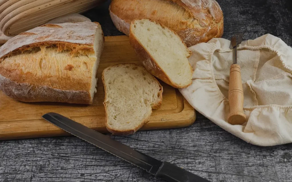 Poêle en fonte avec cornbread doré sur une table en bois, main anonyme versant la pâte