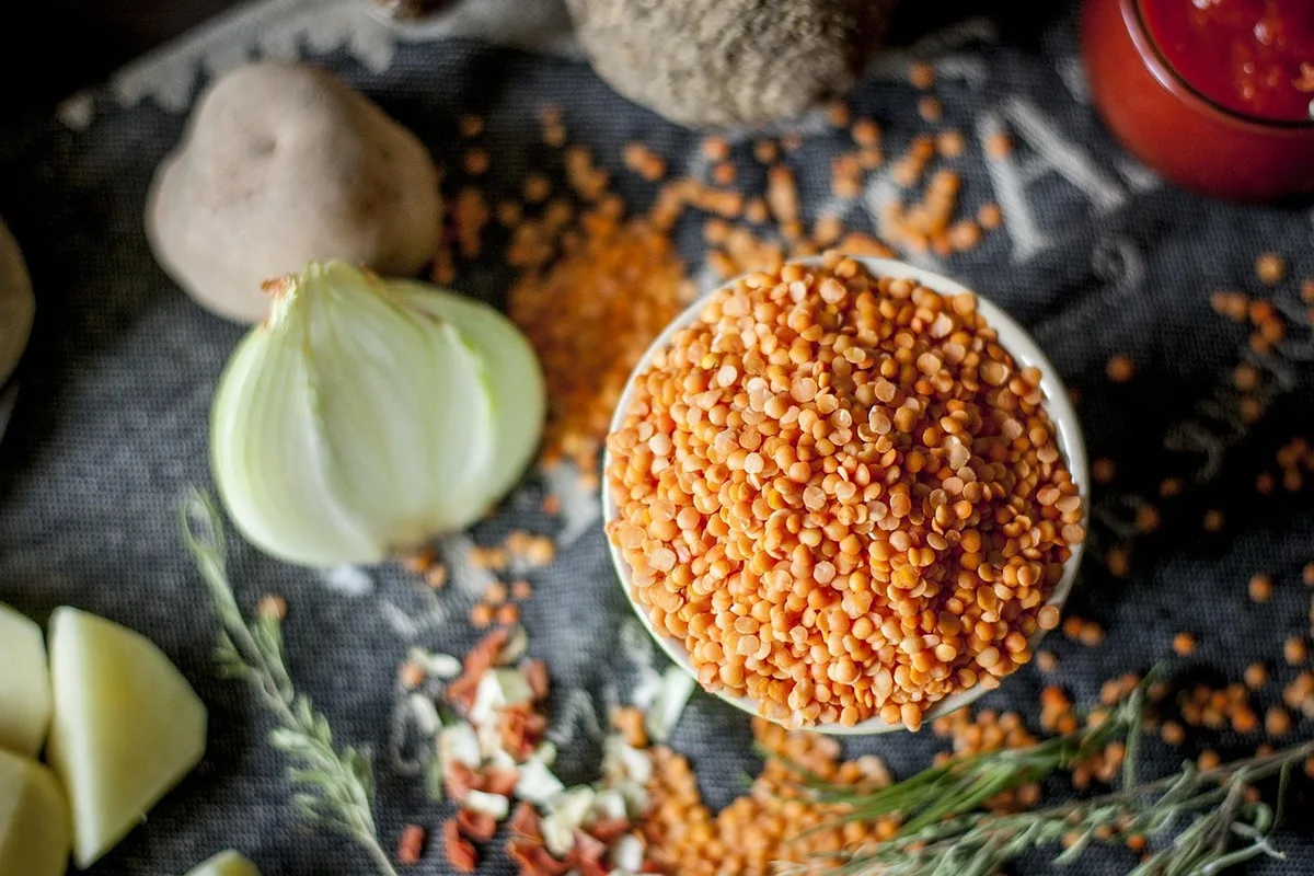 Bols de légumes de saison et vinaigrette sur une table en bois près d'une fenêtre